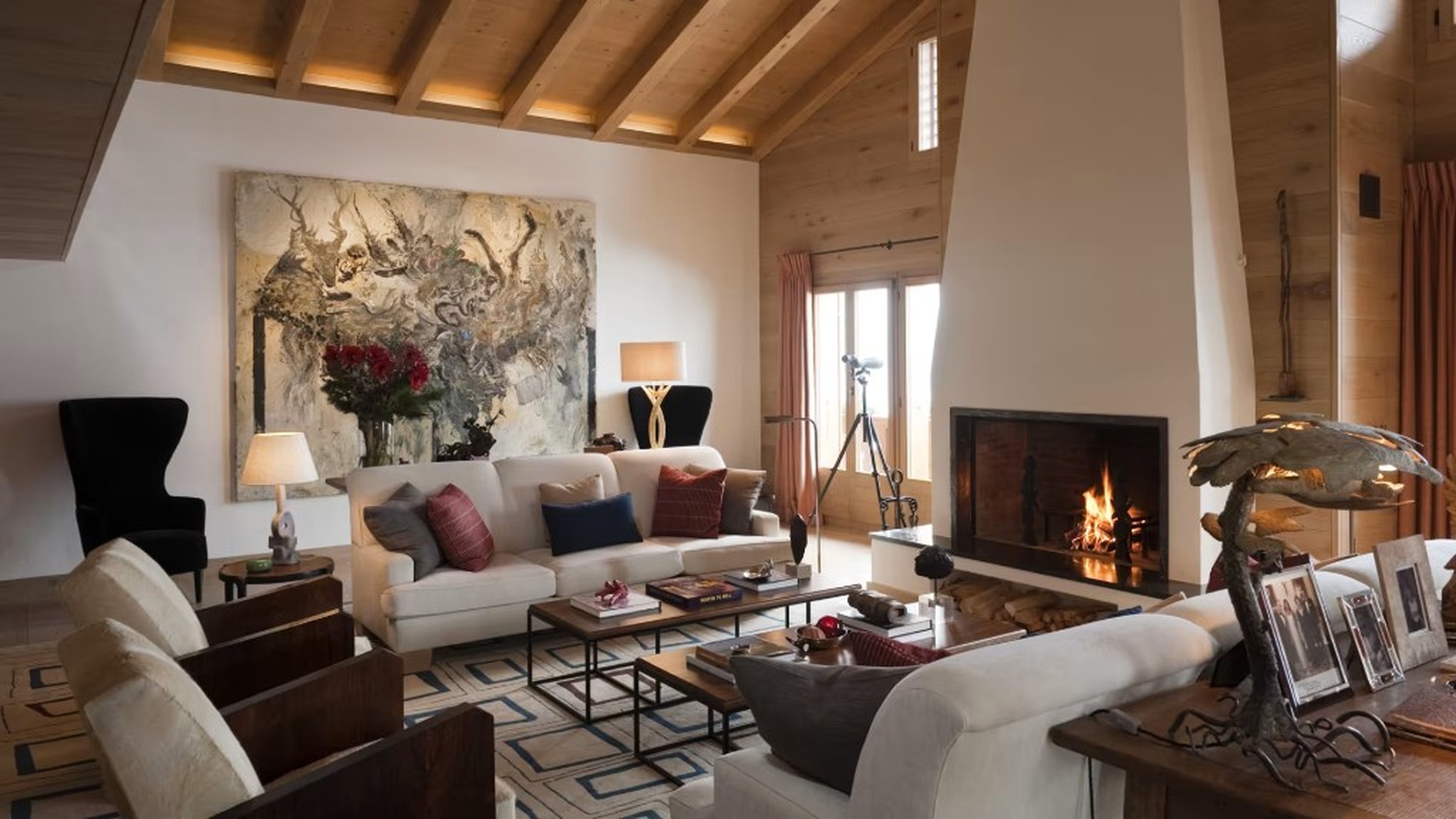 Living cálido con chimenea, sofá y techos de madera